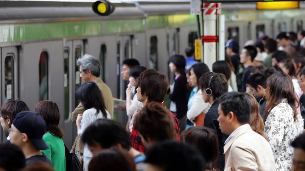 Personas haciendo fila para subirse a los trenes en Japón.