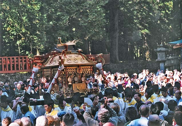 Gente caminando junto a mikoshi.